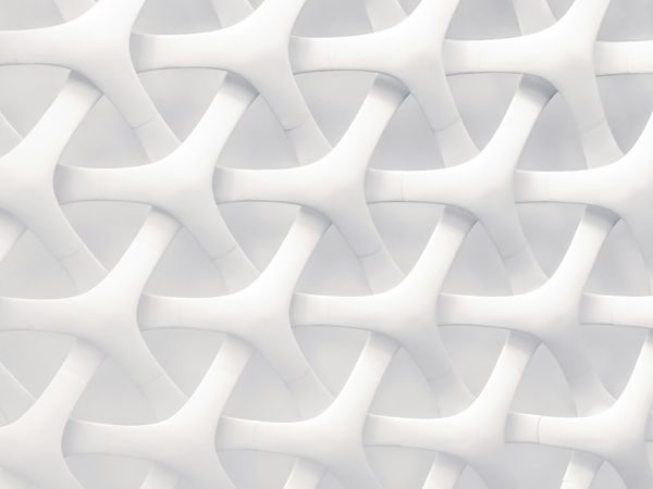 A close-up of a white lattice of interwoven Y-shaped forms repeating across the frame
